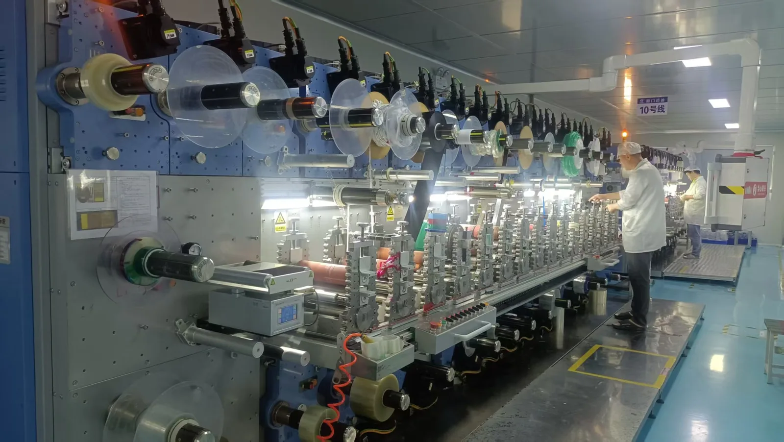 Roll-to-roll rotary die-cutting equipment operating in a controlled production workshop